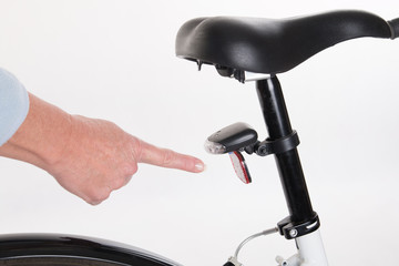 Hand pointing at the rear bike light
