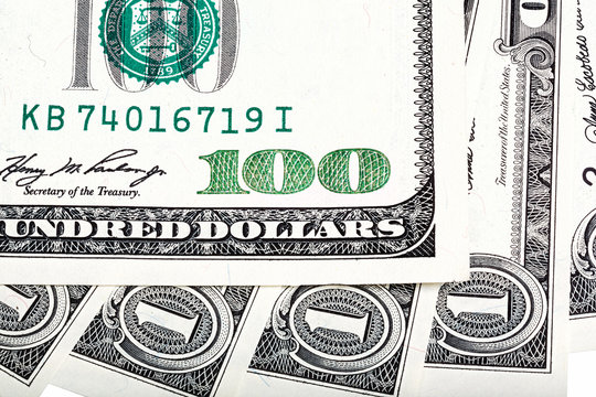 One dollar bills and hundred dollar banknote macro photo.