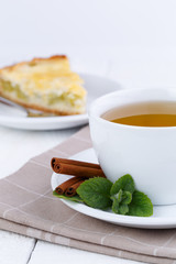 Mint tea with cinnamon on wooden table.