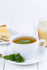 Mint tea with slice of rhubarb pie on wooden table.