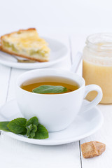 Mint tea with slice of rhubarb pie on wooden table.