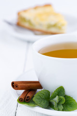 Mint tea with cinnamon on wooden table.