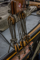 Close up of wooden pully blocks securing the rigging on sail boa
