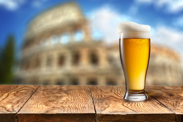 Glass of beer against Colosseum
