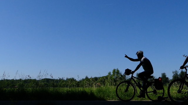 Mountainbiker fahren als Silhouette vorbei, in Zeitlupe