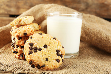 Tasty cookies and glass of milk on rustic wooden background
