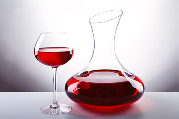 Glass carafe of wine on light background