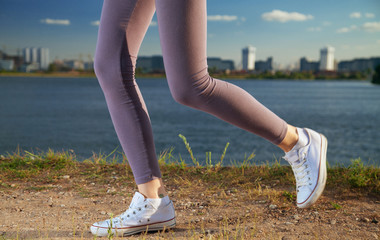 running legs of against the backdrop of the city and the river