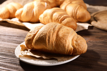 Delicious croissants on plate on table close-up