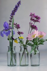 three glas bottles with flowers