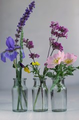 three glas bottles with flowers