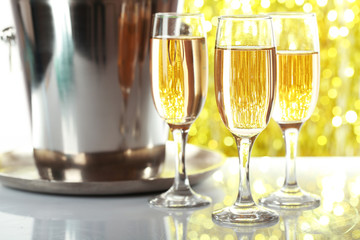 Glasses of champagne on bright background