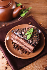 Delicious chocolate cake with mint on plate on table close up