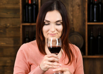 Young woman tasting wine in cellar