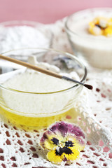 Making candied violet flowers with egg whites and sugar, on color wooden background