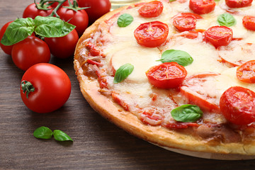 Delicious pizza with cheese and cherry tomatoes on wooden table, closeup