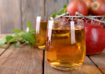 Glasses of apple juice on wooden table, closeup