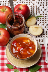 Apple jam and fresh red apples on wooden table close-up