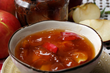 Apple jam and fresh red apples on wooden table close-up
