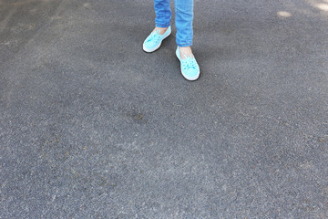 Female feet on gray asphalt background