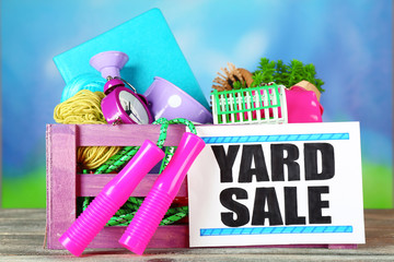 Crate of unwanted stuff ready for yard sale on bright background