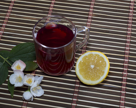 glass of red tea with a lemon on a rug