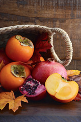 Obraz na płótnie Canvas Basket of fresh persimmons and pomegranates
