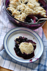 Freshly made fruit cobbler with a portion on a dish