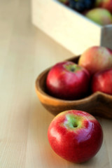 Apples in the wooden box on the table, close up