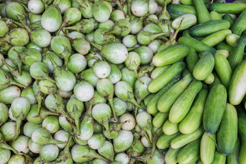 Green eggplants and cucumbers for sale at market, Thailand