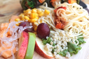 Pasta spaghetti with salad mix fruit.