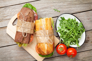 Two sandwiches with salad, ham, cheese and tomatoes