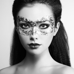 Beautiful young woman in gold mysterious mask