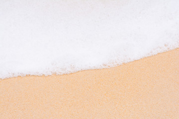 Fototapeta na wymiar the white foam of wave on the sand