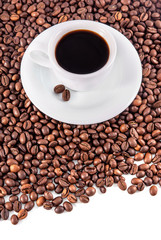 Cup of coffee with saucer and beans on white background