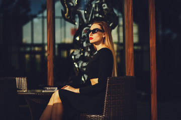 fashionable girl sitting in a cafe looking away