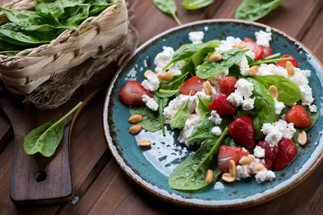 Salad with strawberries, spinach leaves and cheese, studio shot