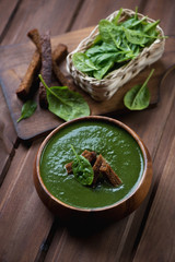 Wooden bowl with freshly made spinach soup, studio shot