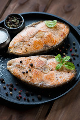 Close-up of roasted salmon steaks with spices in a frying pan