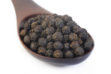 Black pepper seeds in wooden spoon