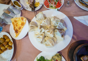 Khinkali dumplings and piece of khachapuri - traditional food in Georgia
