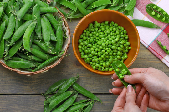 Woman hands hulled peas from shell