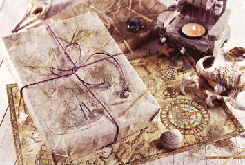 Retro still life with wrapped gift, shells and pirate map