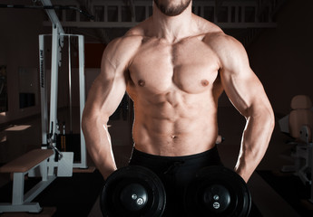 Fototapeta na wymiar Closeup of a muscular young man lifting weights