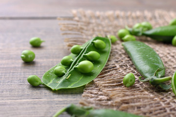 Fresh green peas on a wooden background. Peas on sacking