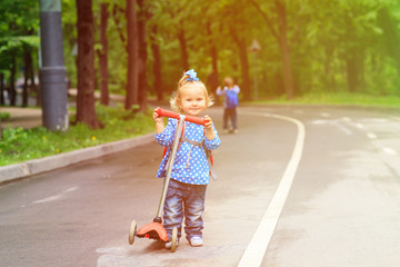 little boy and toddler girl riding scooters in the city