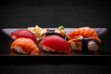 Tuna, salmon and eel sushi on dark background
