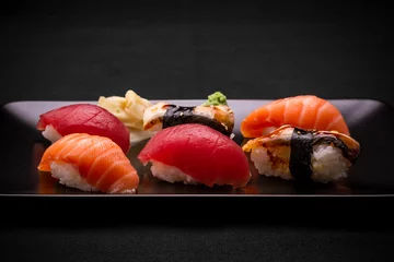 Selbstklebende Fototapeten Thunfisch, Lachs und Aal Sushi auf dunklem Hintergrund © diamant24