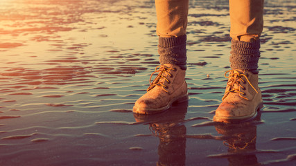 Young girl walking on a beach at low tide, feet detail, adventure concept - obrazy, fototapety, plakaty