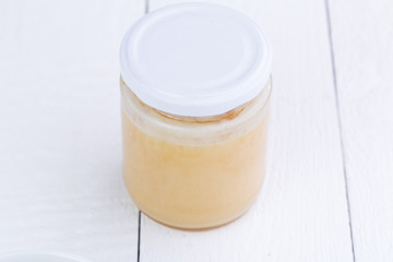 Jar of honey on wooden table.